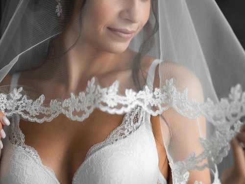 Sposa che indossa il suo velo e un intimo bianco da indossa sotto l'abito da sposa.