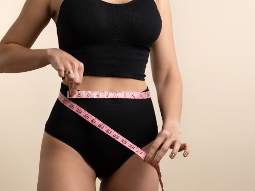 Donna in intimo che prende le misure del corpo 